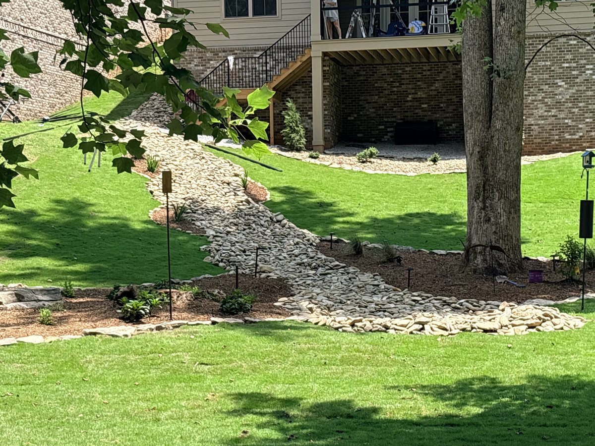 Dry creek bed and native plantings installed by Iron Lungs Grading in Travelers Rest, SC to control runoff
