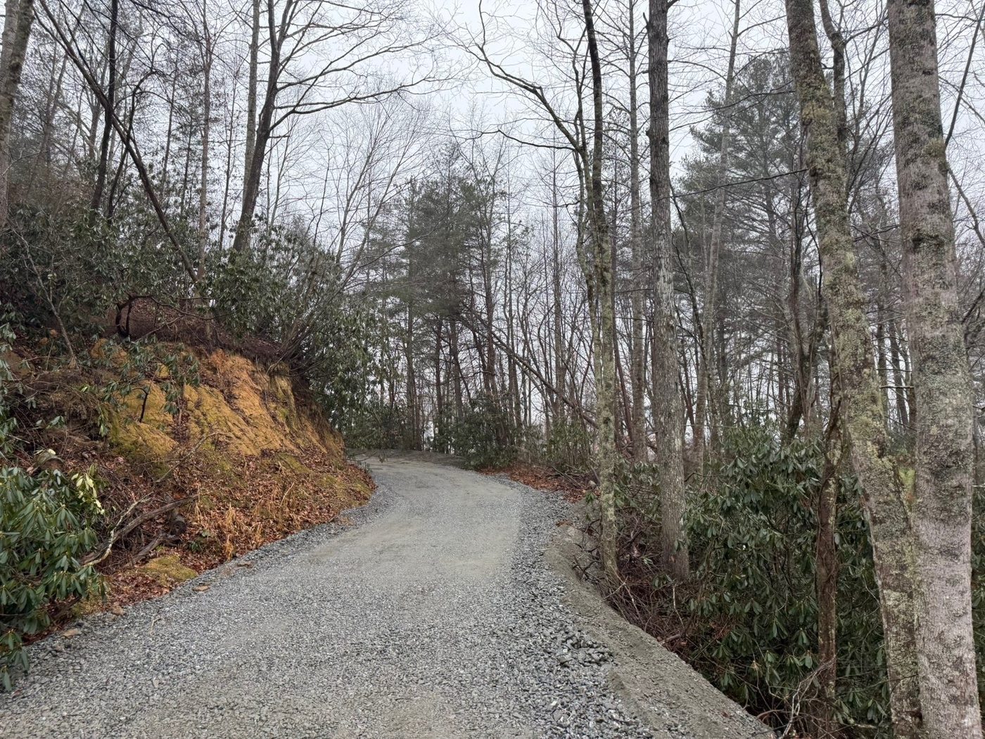 Gravel driveway with rock border erosion control — mountain property Hendersonville NC Iron Lungs